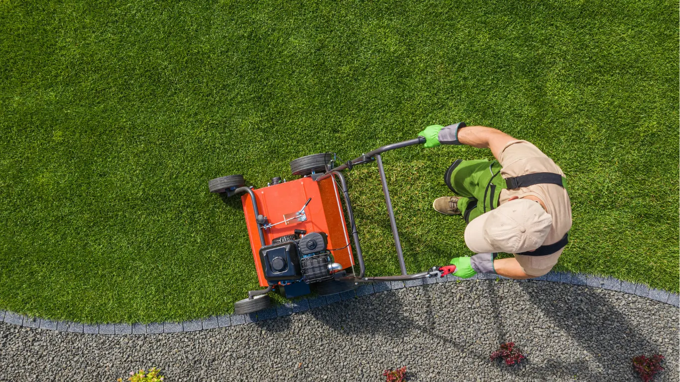 Professional mowing a striped residential lawn